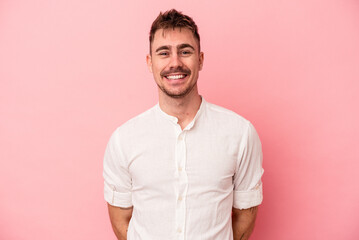 Young caucasian man isolated on pink background happy, smiling and cheerful.