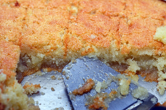 Selective focus of a tray of basbosa cut in pieces with honey sugary syrup on it, Basbusa is a middle eastern dessert that is usually baked in Ramadan month, Arabian sweet cuisine