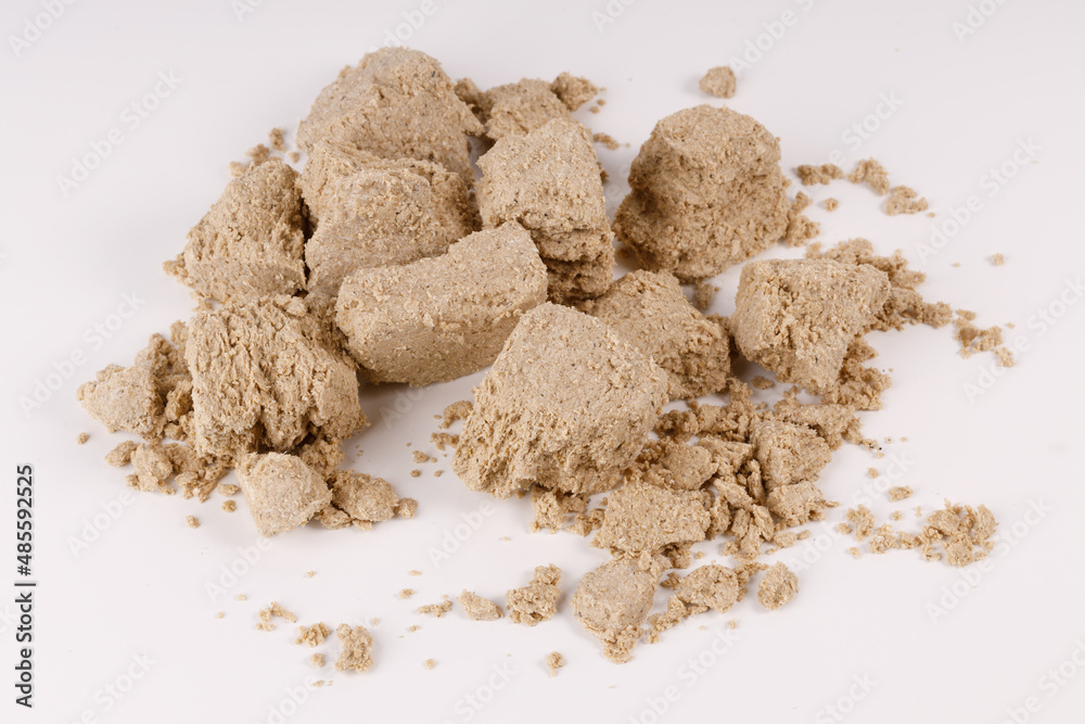 Poster a large pile of halva with crumbs on a white background