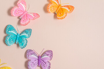multicolored handmade butterflies on a pale pink background, free space for text, elegant spring composition