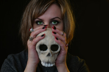 portrait of a witch woman with a skull in her hand