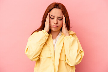 Young caucasian woman isolated on pink background having a head ache, touching front of the face.