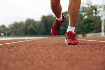 Young man running in athletics track to healthy.