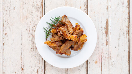 grilled beef fillet steak meat with oregano and rosemary in white plate on white wood texture background, top view, light and airy food photography