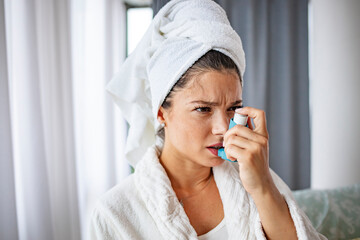 A beautiful woman in her late 30s inhaled asthma medicine at home. A woman lives with a chronic disease every day and overcomes challenges with it. She took her inhaler home in the living room