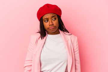 Young african american woman isolated on pink background  shrugs shoulders and open eyes confused.