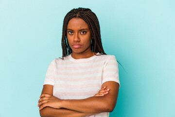 Young african american woman isolated on blue background  suspicious, uncertain, examining you.