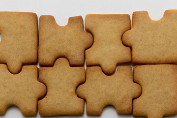 jigsaw, puzzle shaped cookies close up the white background, horizontal copy space pastry...