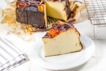 Homemade Burnt Basque Cheesecake,  Piece of Basque burnt cheesecake with berry decor and whole cake. Tarta de Queso Spanish recipe concept