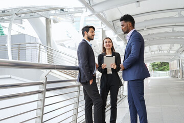 young business people discussing project on digital tablet computer outdoors