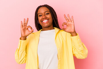 Young african american woman isolated on pink background  cheerful and confident showing ok gesture.