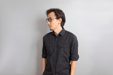 Obraz premium Middle age Asian man in black shirt smile on grey background.