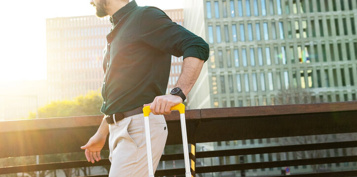 Anonymous confident businessman with suitcase on footbridge