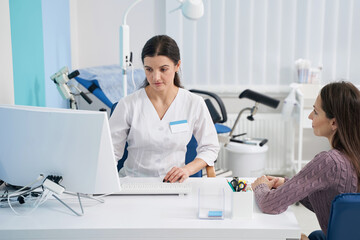 Focused lady doctor receiving client in her office