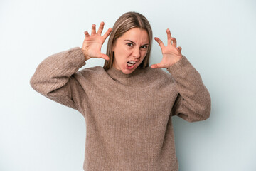 Young caucasian woman isolated on blue background upset screaming with tense hands.