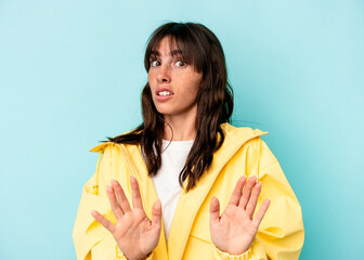Young Argentinian woman isolated on blue background rejecting someone showing a gesture of disgust.