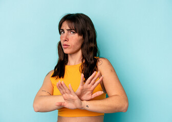 Young Argentinian woman isolated on blue background doing a denial gesture