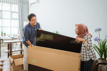 Excited Couple Setting Up New Television At Home