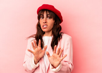 Young Argentinian woman isolated on pink background rejecting someone showing a gesture of disgust.