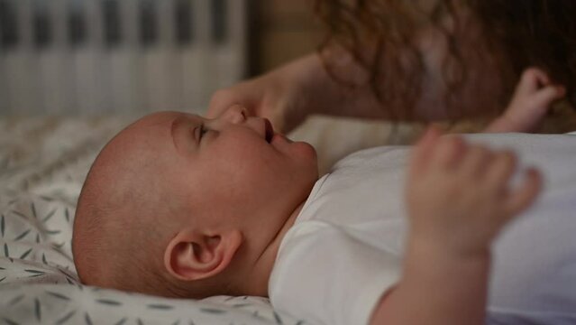 Mother tickling her baby with her hair. 