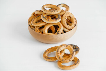 Dried bagels with poppy seeds in a wooden bowl on a white background