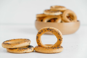 Dried bagels with poppy seeds in a wooden bowl on a white background