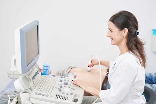 Joyous young diagnostician carrying out ultrasound exam