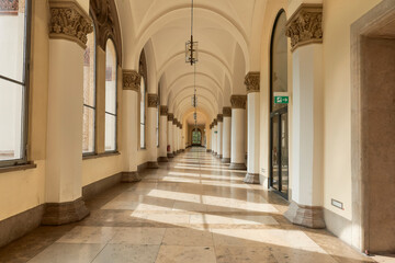Fototapeta na wymiar Corridor with attached pillars and columns with Corinthian capitals and large windows