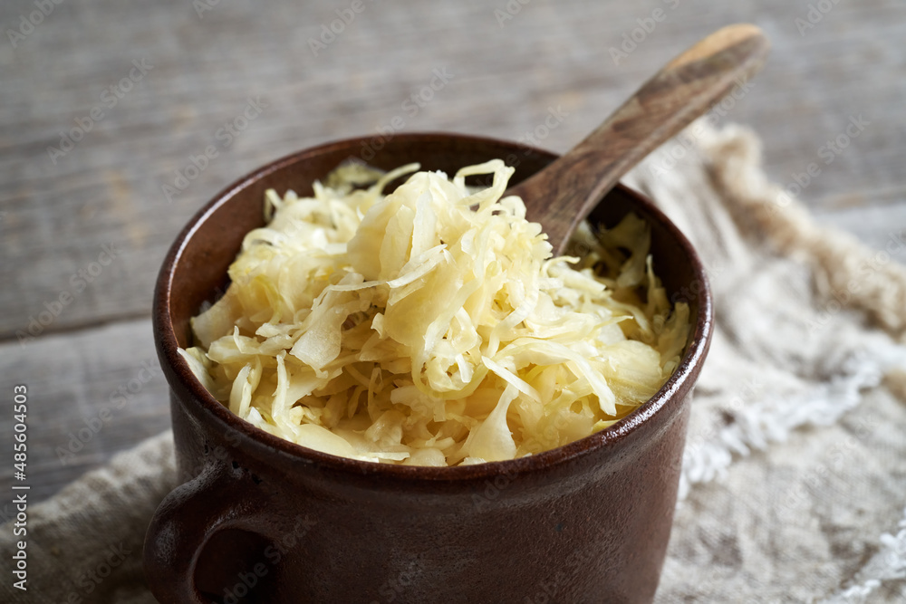 Wall mural Fermented cabbage or sauerkraut in a brown pot