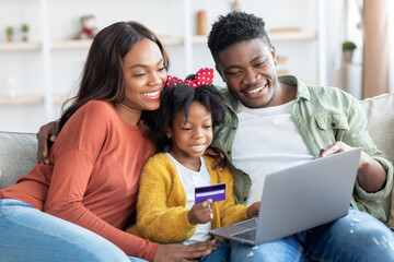 Cheerful African American Family With Laptop And Credit Card Making Online Shopping