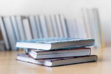 Book stack in the room and blurred bookshelf for business and education background, back to school concept