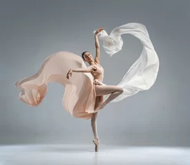 Gardinen Beautiful ballerina dancing in the body color ballet leotard with body color cloth. She danced on ballet pointe shoes. © Alina