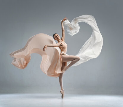 Fototapeta Beautiful ballerina dancing in the body color ballet leotard with body color cloth. She danced on ballet pointe shoes.