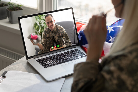 Mature male soldier using laptop in headquarters building for communication with his family. - Powered by Adobe