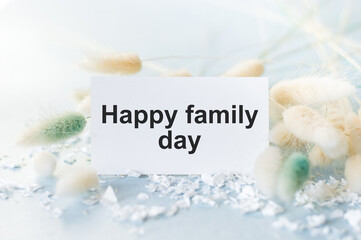 Naklejka premium Happy family day text on a white card on a festive background, family, home