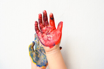 Colourful painted two child hands up isolated on white background. Creative, funny, artistic and happy