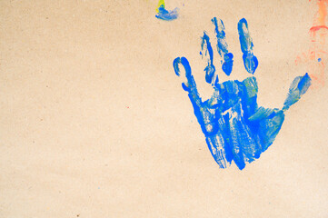 imprint colorful child hand isolated on brown paper. Close up. copy space. Creative, funny, artistic, and happy