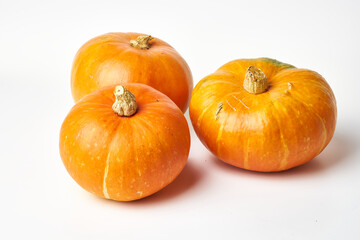 three yellow pumpkins on a white background