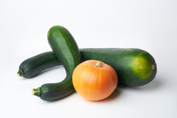 two green zucchini and an orange pumpkin on a white background