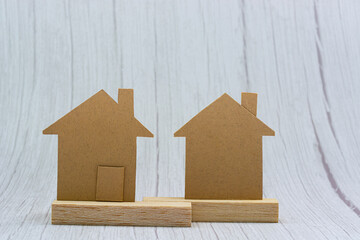 Obraz na płótnie Canvas House brown paper model on white wooden background. Property investment concept