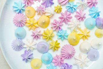 Closeup of delicious colorful meringue cookies on plate. Sweet decor. Confectionery 