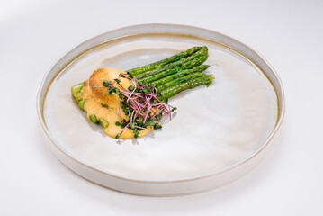 Cooked asparagus with poached egg and microgreen. Diet menu