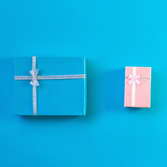 Gift boxes decorated with ribbon and red heart on blue background, copy space. Flat lay, pink and blue present boxes, top view. Valentine or love, spring holidays, Christmas and birthday concept.