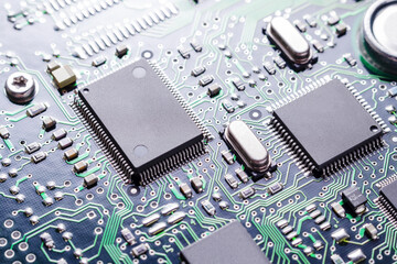 Close up of PCB. High tech technology background with printed circuit board, chips and many electronic components, selective focus.