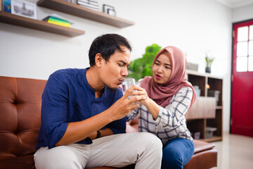 asian young couple drinking a glass of water during ramadan