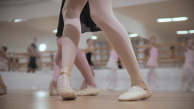 Ballet training - group of little girls stands on the pointe shoes