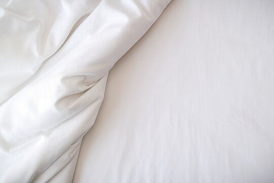 White bedding sheets on bed in bedroom. Morning lifestyle concept.