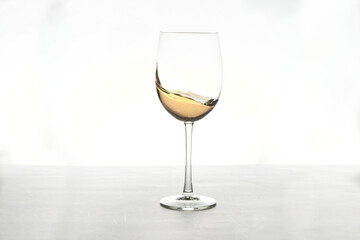 glass of white wine splashing on white background