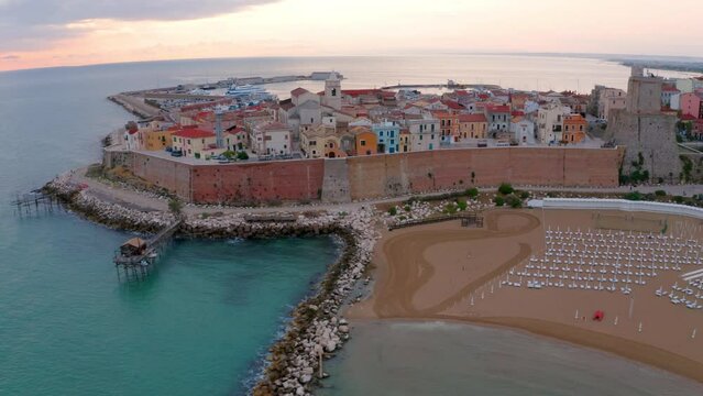 4k drone flight moving to the side footage (Ultra High Definition) of Sant'Antonio beach. Exciting morning cityscape of Termoli port. Spectacular sunrise on Adriatic sea.