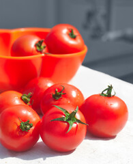 Ripe, juicy tomatoes (variety available in West Bengal, India) on white fabric drapery.
